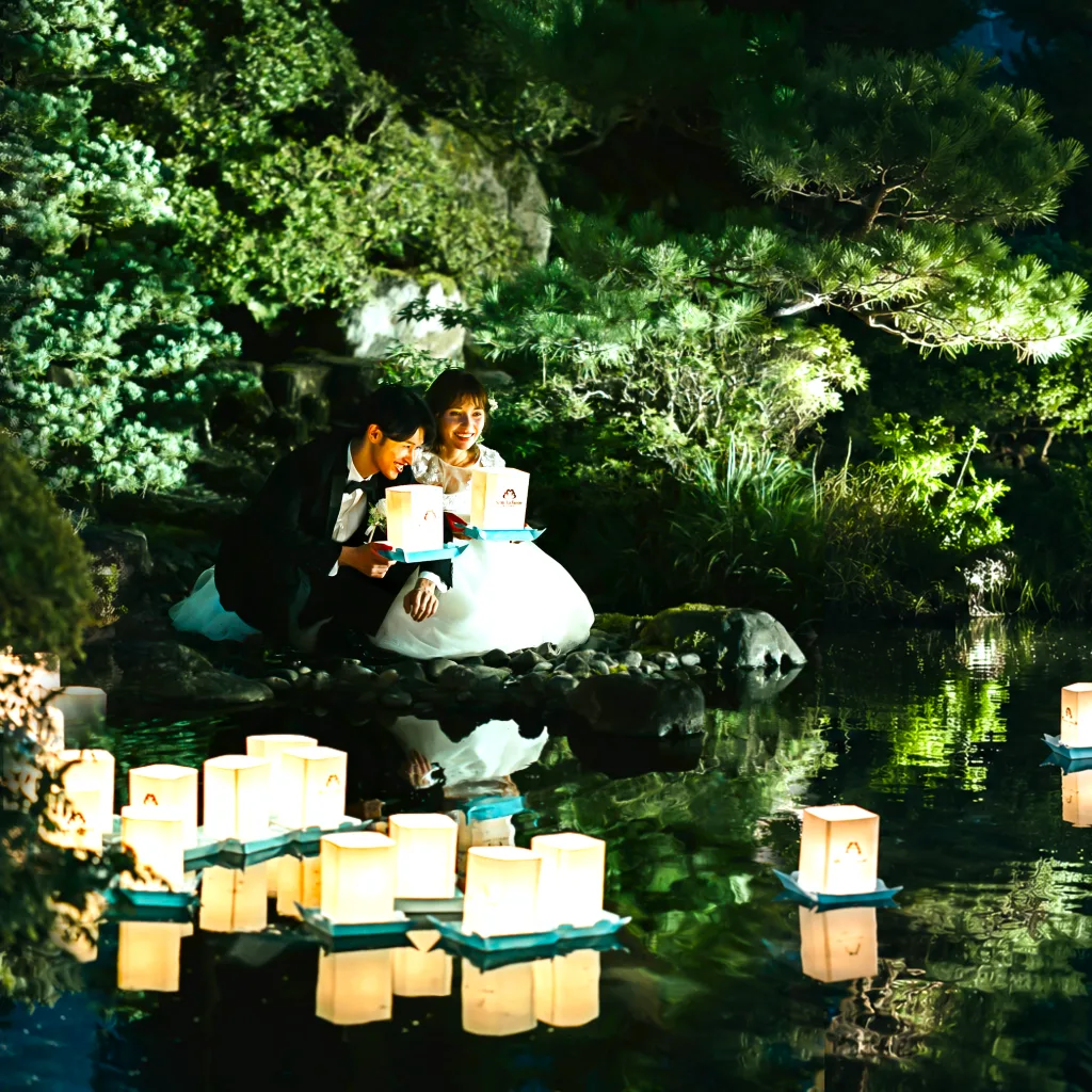 夜の庭園にランタンを浮かべる結婚式
